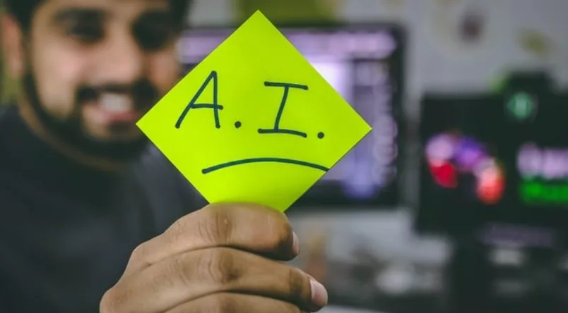 Man holding up sign that spells out Artificial Intelligence