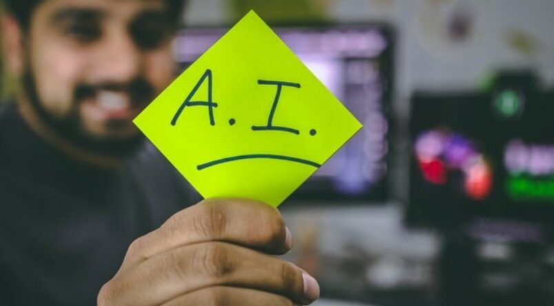 Man holding up sign that spells out Artificial Intelligence